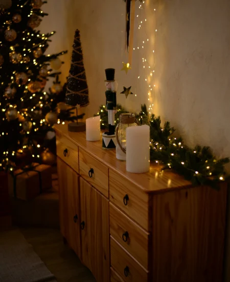 Festive Christmas table setting with candles, pinecones, and holiday colors.