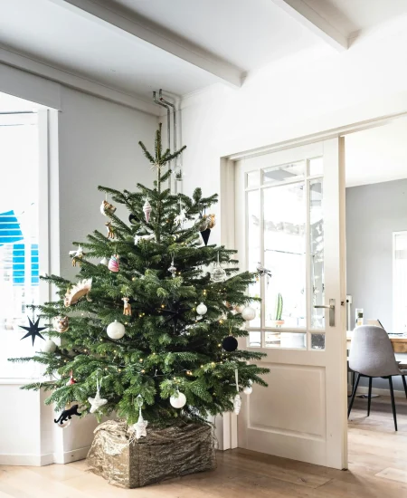 Elegant Christmas tree decoration for entryway with festive ornaments.