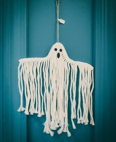 Handmade ghost decoration made from white string for Halloween home decor.