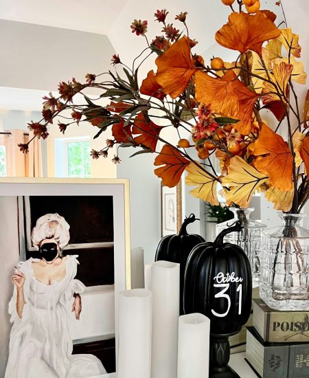 Glass vase filled with autumn leaves on a wooden table