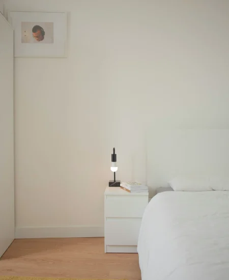 Minimalist bedroom with neutral bedding, light wood furniture, and calm atmosphere